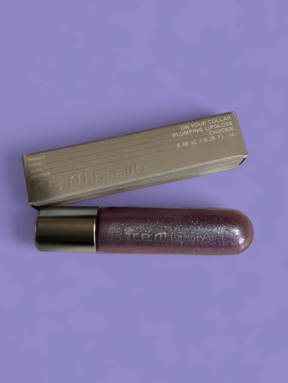 R.E.M. Beauty Plumping Iridescent Purple Lip Gloss in shade Chuckie